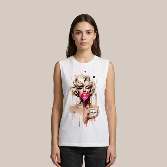 A woman modeling a white sleeveless crop top with a colorful graphic print of a Marilyn Monroe-style face blowing a pink bubblegum bubble and holding a coffee mug, set against a plain beige studio background.
