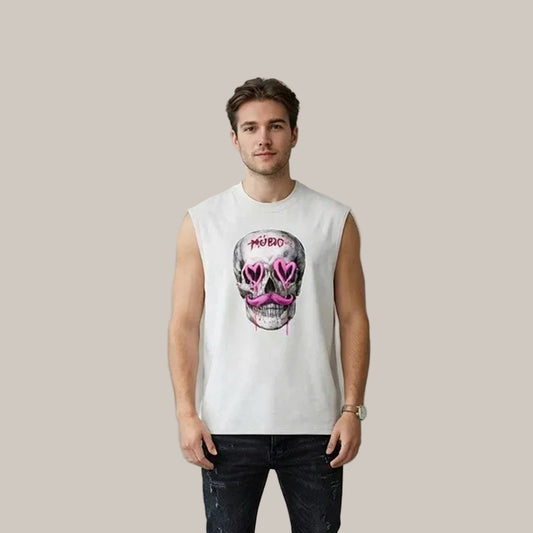 A man wearing a white sleeveless t-shirt with a graphic of a skull wearing pink heart-shaped sunglasses and the word 'MURDER' above it, paired with dark jeans, standing against a textured gray wall.